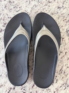 OOFOS Women’s Black Flip Flops with Metallic Silver Straps